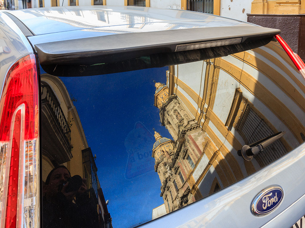 La iglesia de San Luis de los Franceses reflejada en la luneta de un coche