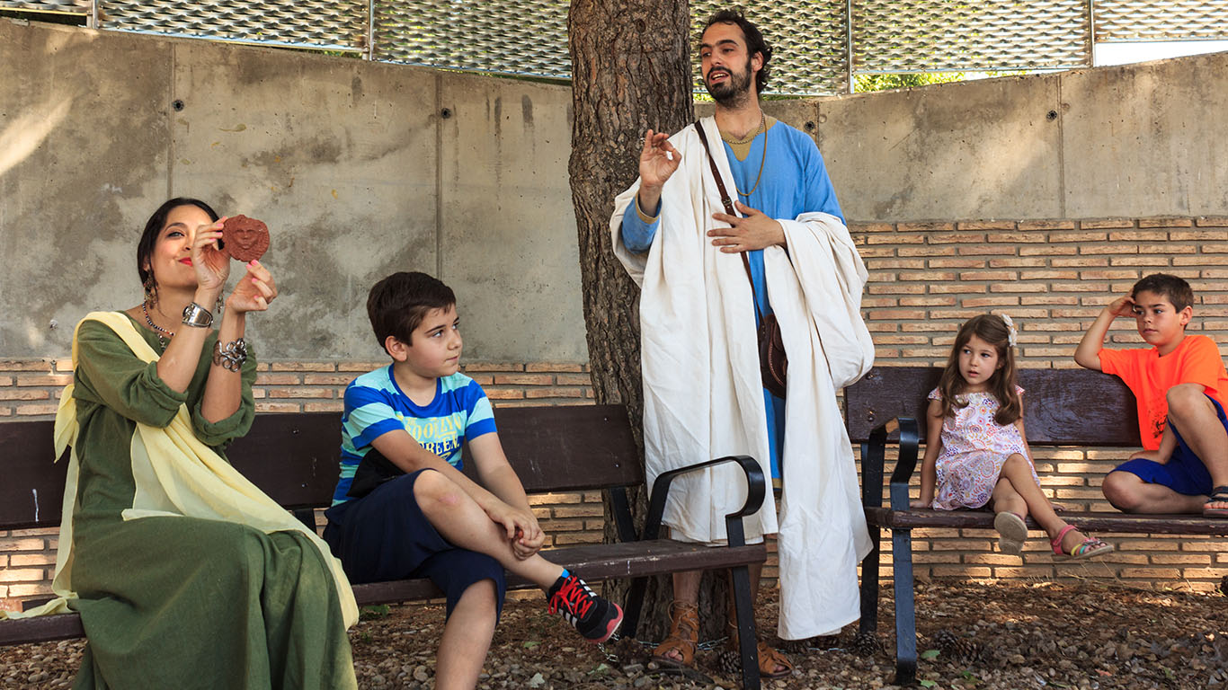 Personajes enseñando a los niños cómo era la vida en la época romana